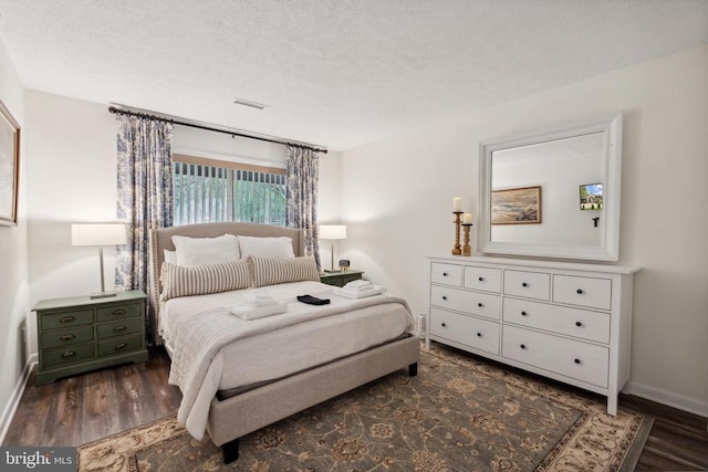 bedroom featuring dark hardwood / wood-style floors and a textured ceiling