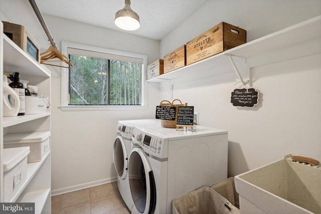 laundry area with sink, washing machine and clothes dryer, and light tile patterned floors