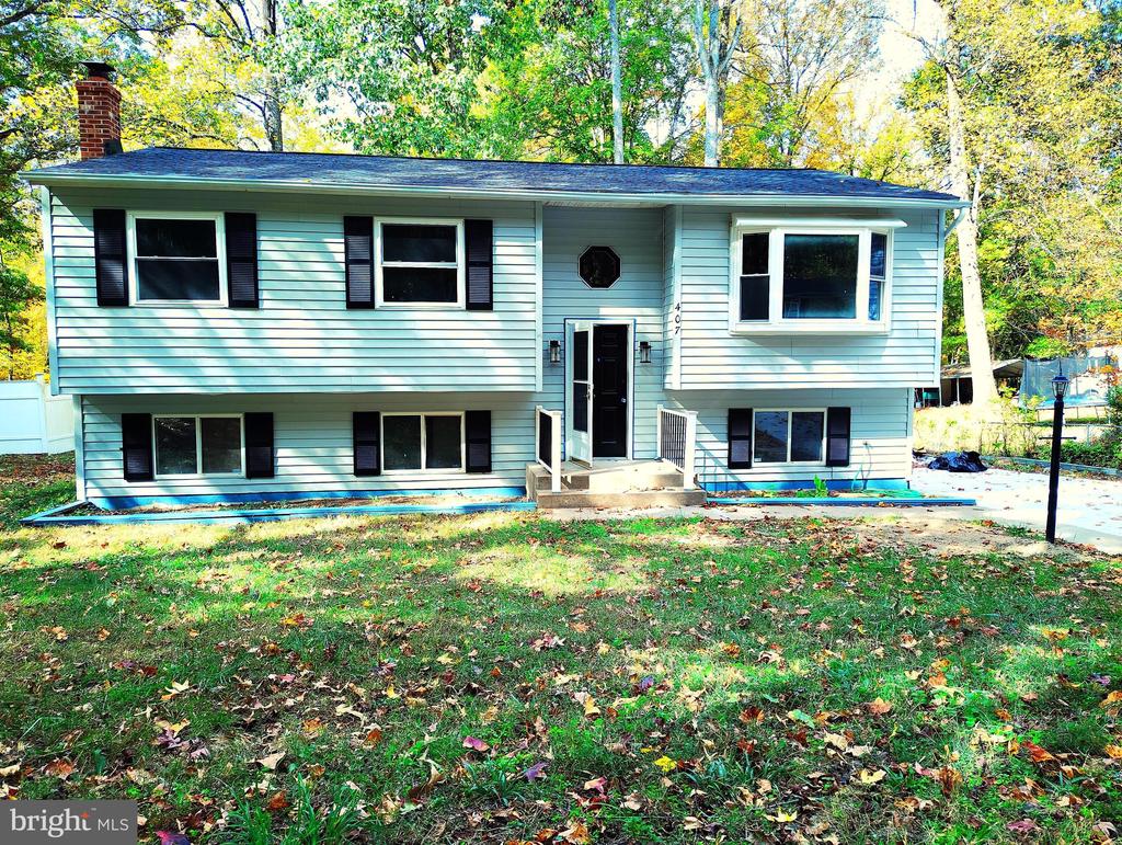 split foyer home featuring a front yard and a chimney