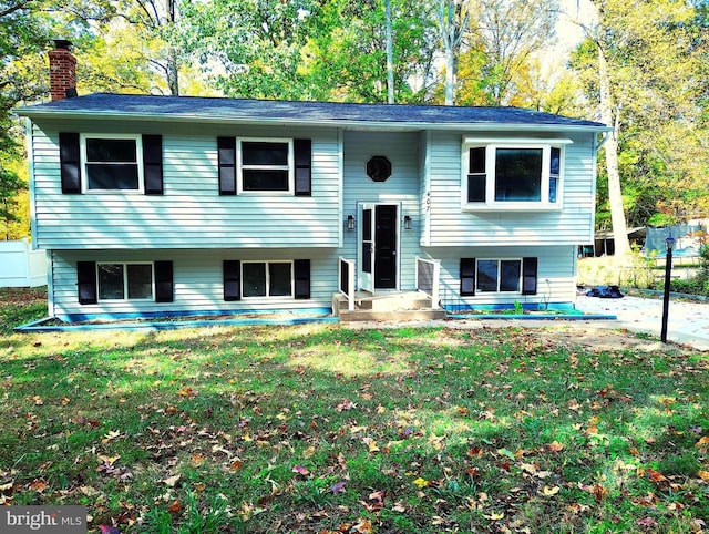 split foyer home featuring a front yard and a chimney