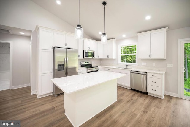 kitchen featuring white cabinetry, appliances with stainless steel finishes, and vaulted ceiling