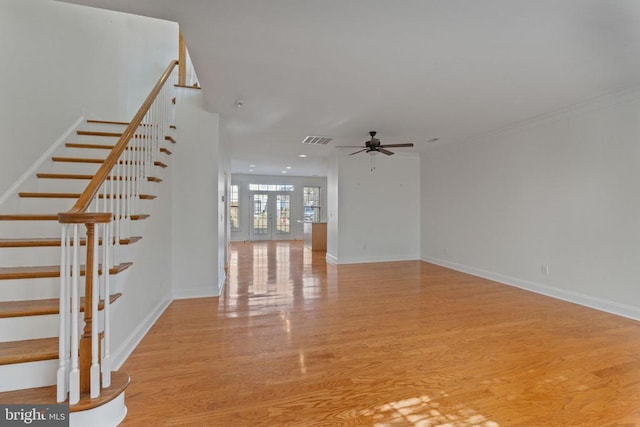 unfurnished living room featuring ceiling fan, french doors, and light wood-type flooring