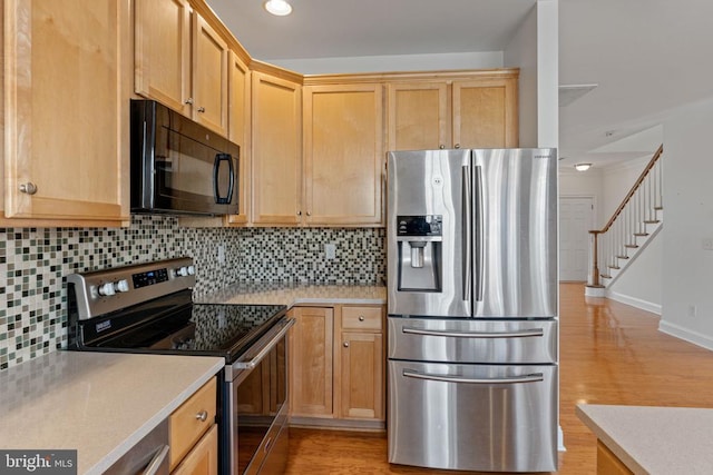 kitchen featuring decorative backsplash, stainless steel appliances, and light hardwood / wood-style flooring