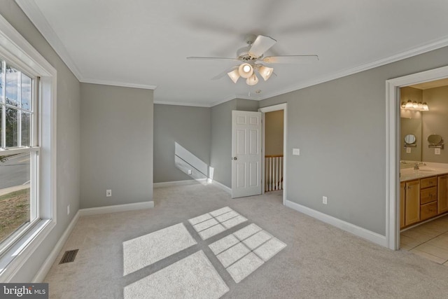 unfurnished room with ceiling fan, light colored carpet, ornamental molding, and sink