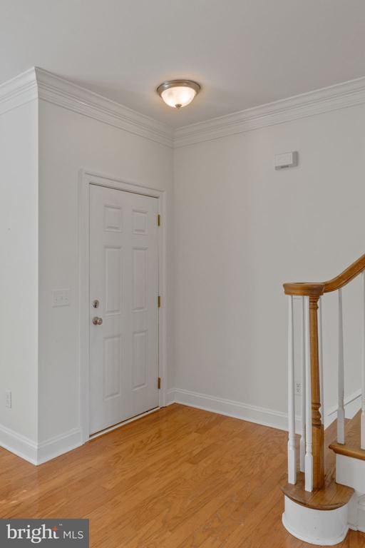 foyer entrance featuring hardwood / wood-style floors and ornamental molding