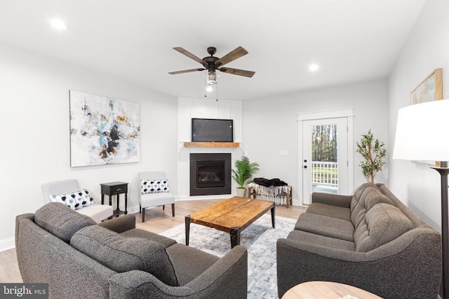 living room featuring ceiling fan and light hardwood / wood-style flooring