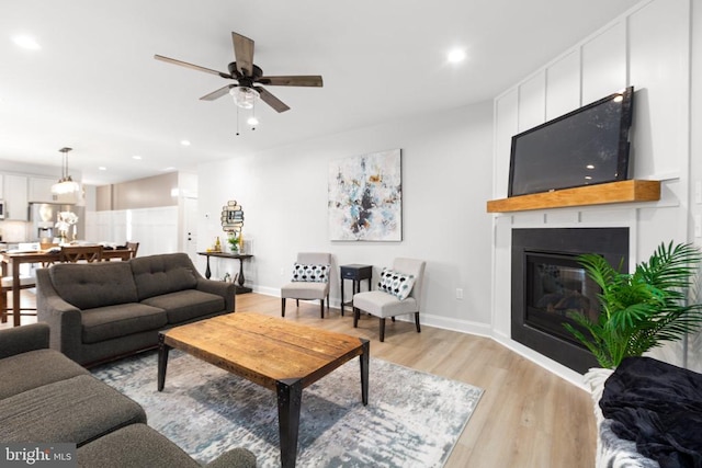 living room featuring ceiling fan and light hardwood / wood-style floors