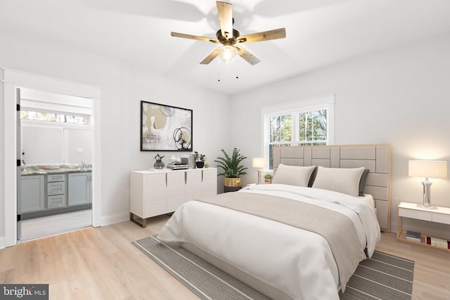 bedroom featuring ceiling fan, light hardwood / wood-style flooring, and ensuite bathroom