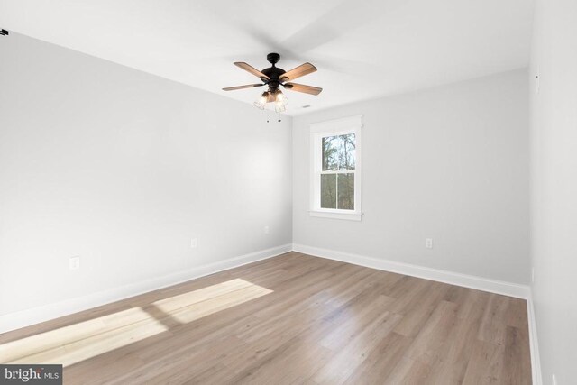 empty room with ceiling fan and light hardwood / wood-style flooring