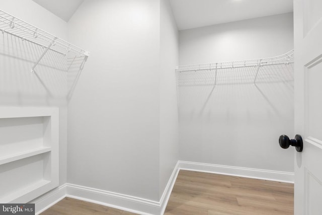 walk in closet with hardwood / wood-style floors