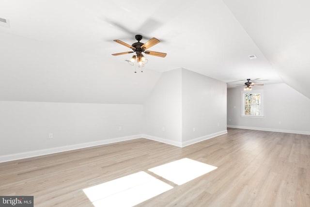 additional living space featuring light wood-type flooring, ceiling fan, and lofted ceiling