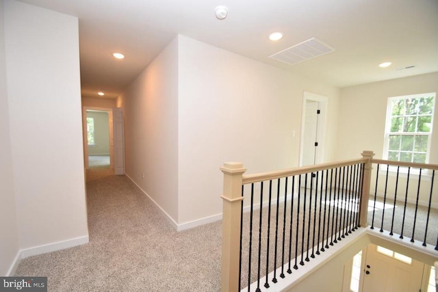 hall featuring light colored carpet