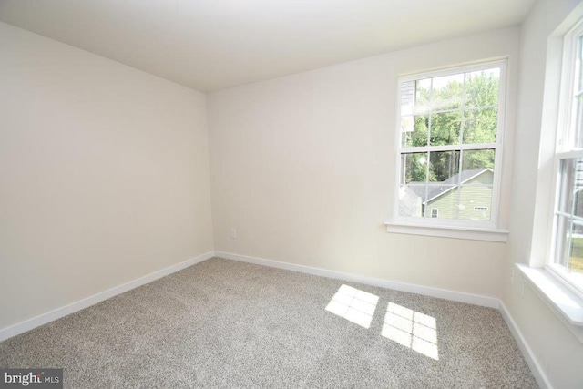 carpeted spare room with a healthy amount of sunlight