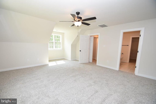 additional living space with light carpet, vaulted ceiling, and ceiling fan