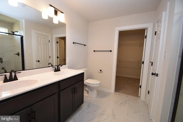 bathroom featuring vanity, toilet, and a shower with shower door