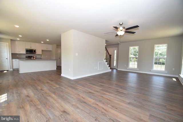 unfurnished living room featuring hardwood / wood-style floors and ceiling fan