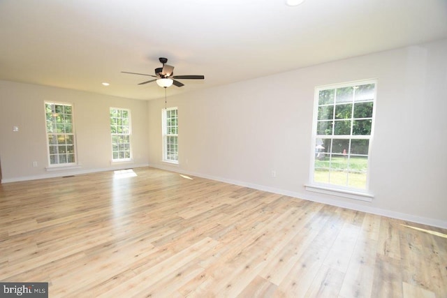 empty room with ceiling fan and light hardwood / wood-style flooring