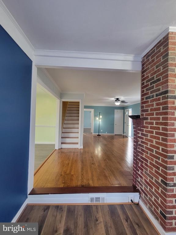 hallway with hardwood / wood-style floors and crown molding