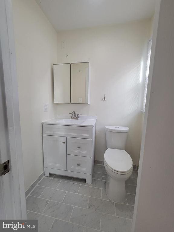 bathroom featuring toilet, vanity, and tile patterned flooring