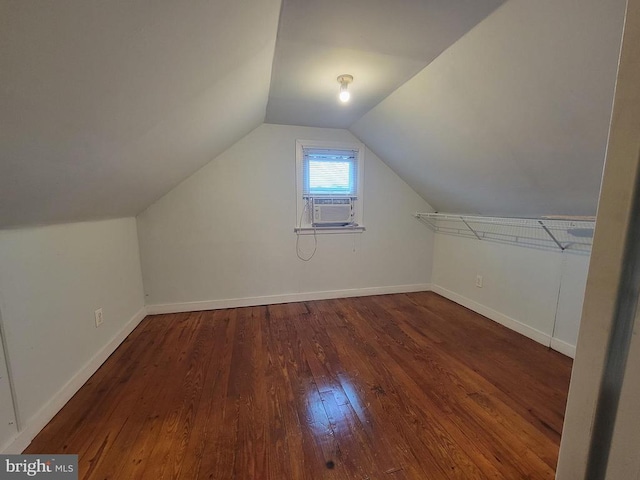 additional living space with dark wood-type flooring, cooling unit, and lofted ceiling