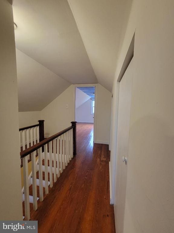 corridor with dark hardwood / wood-style flooring and lofted ceiling