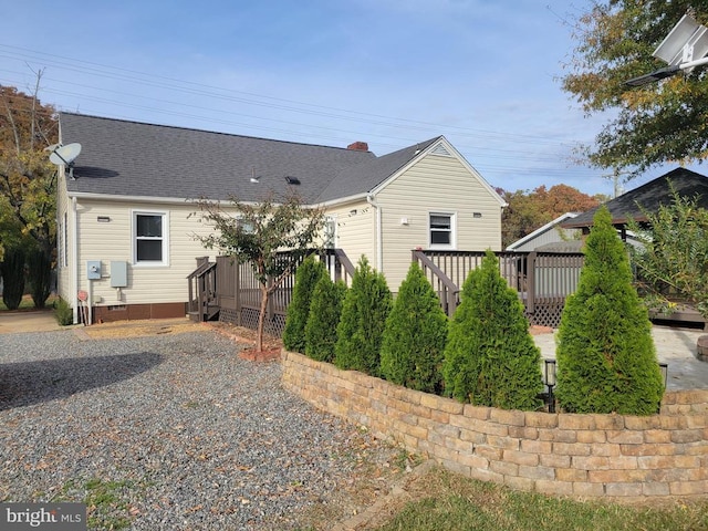 view of side of property featuring a deck and a patio area