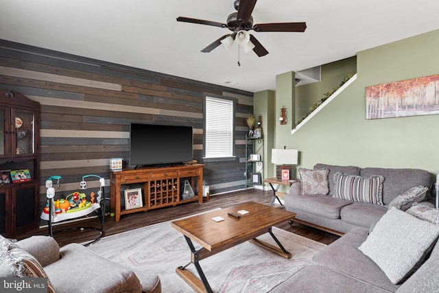 living room featuring wooden walls, hardwood / wood-style flooring, and ceiling fan