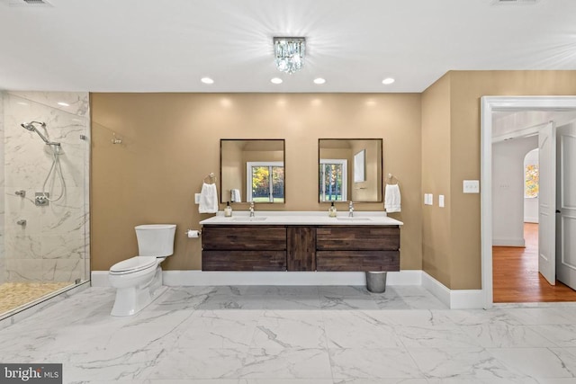 bathroom with tiled shower, vanity, a chandelier, and toilet