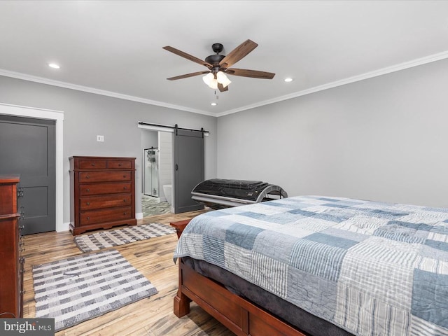 bedroom with a barn door, ceiling fan, light hardwood / wood-style flooring, and crown molding