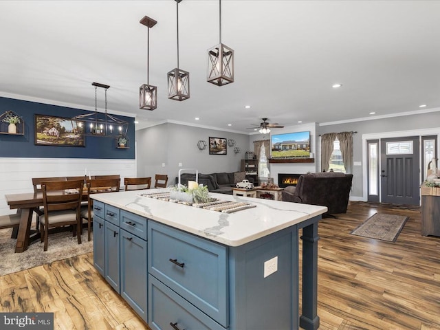 kitchen with hardwood / wood-style flooring, blue cabinets, pendant lighting, and a center island