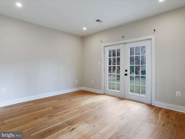 empty room with french doors and light hardwood / wood-style floors