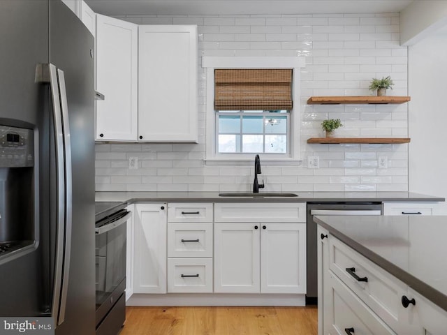 kitchen featuring white cabinetry, appliances with stainless steel finishes, tasteful backsplash, and light hardwood / wood-style flooring