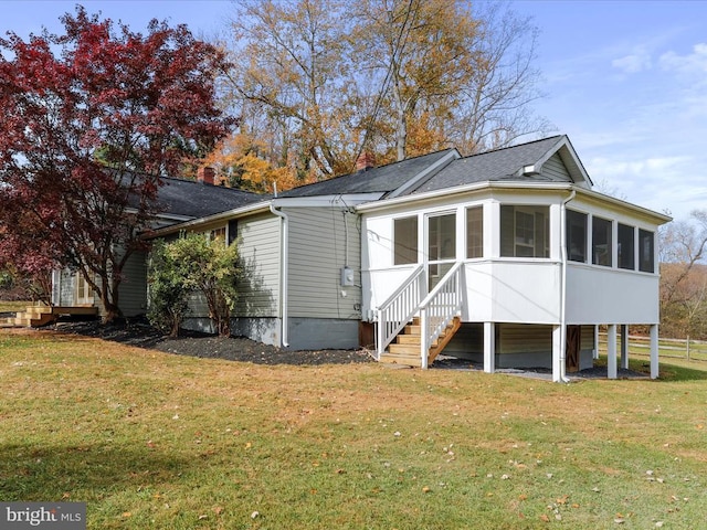 back of house with a sunroom and a yard