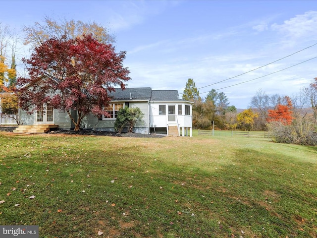 exterior space featuring a sunroom and a yard