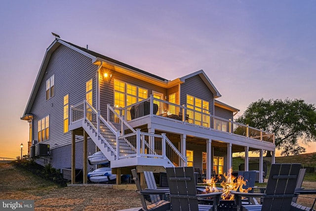 back house at dusk with a fire pit and a deck