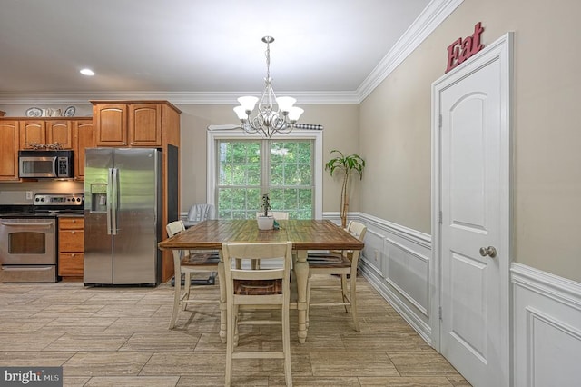 kitchen with a chandelier, ornamental molding, pendant lighting, and appliances with stainless steel finishes