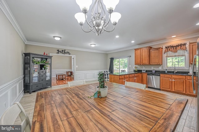 unfurnished dining area featuring crown molding, light hardwood / wood-style flooring, sink, and an inviting chandelier