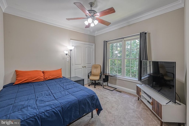 carpeted bedroom with ceiling fan and ornamental molding