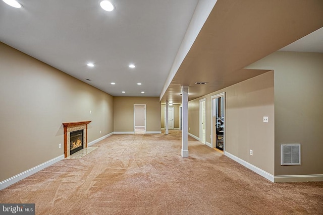 basement with light colored carpet and a fireplace