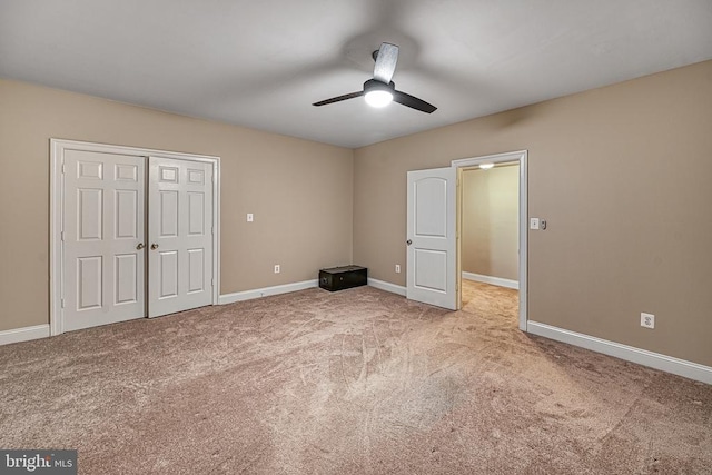 unfurnished bedroom featuring a closet, light colored carpet, and ceiling fan