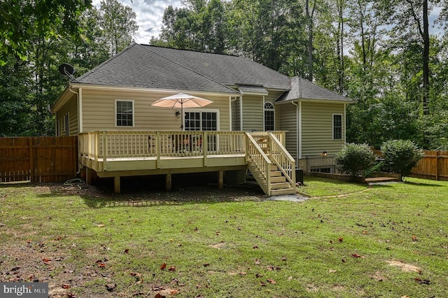 rear view of property featuring a lawn and a wooden deck