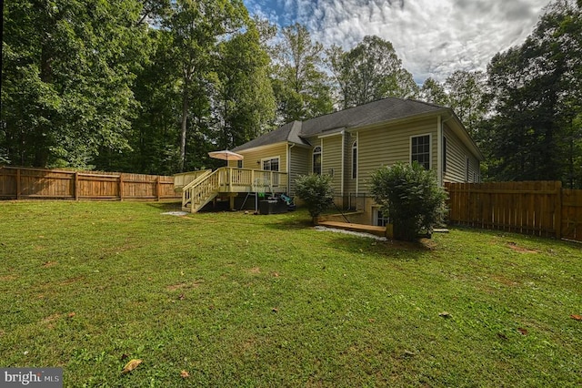 rear view of property with a deck and a yard