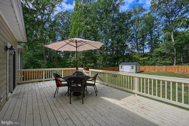 wooden deck featuring a shed and a lawn