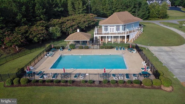 view of pool with a patio and a lawn