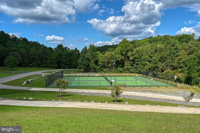 view of community featuring a lawn and tennis court