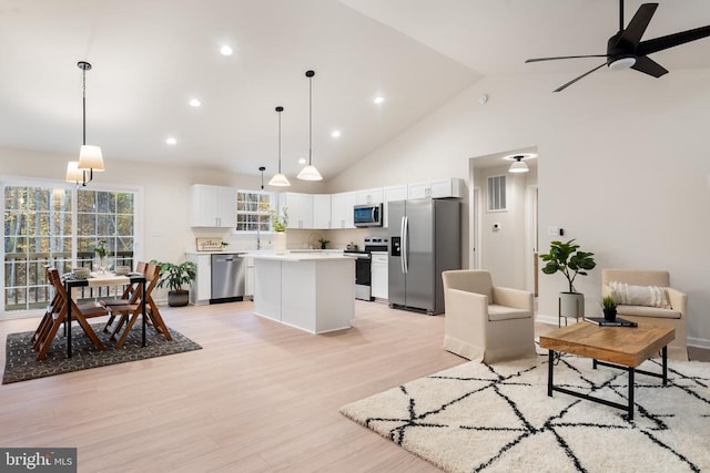 living room featuring high vaulted ceiling, light hardwood / wood-style flooring, and ceiling fan