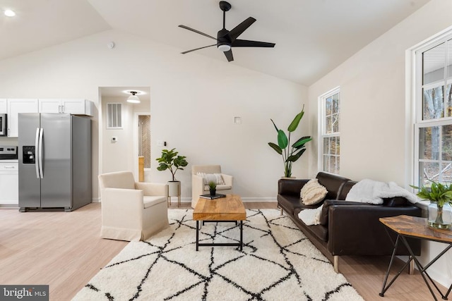 living room with light wood-type flooring, lofted ceiling, and ceiling fan