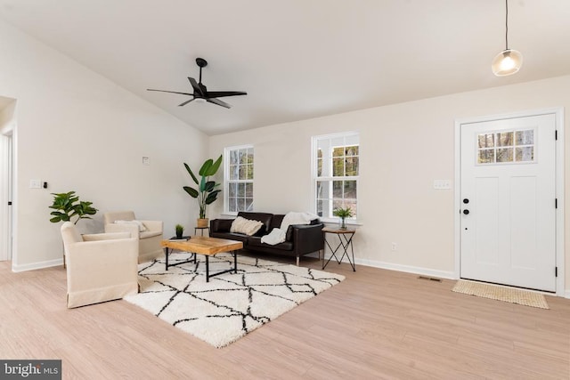 living room featuring ceiling fan, vaulted ceiling, and light hardwood / wood-style floors