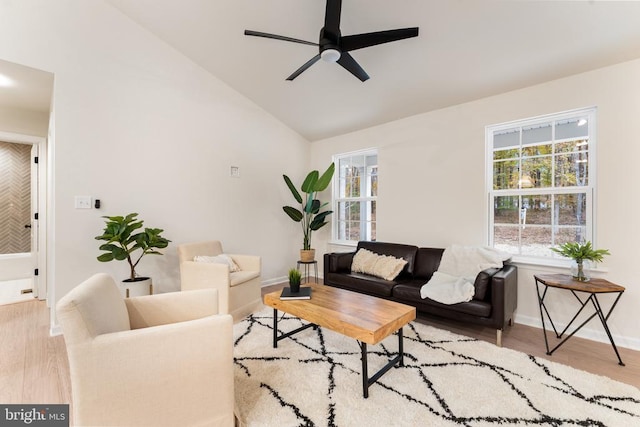 living room with ceiling fan, light wood-type flooring, and vaulted ceiling