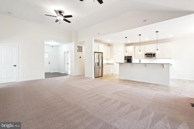 unfurnished living room featuring ceiling fan, light carpet, and lofted ceiling